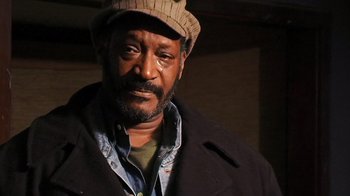 Movie still from “The Man from Earth” (2007), directed by Richard Schenkman – A person wearing a hat and a jacket; Close Up shot, Low angle