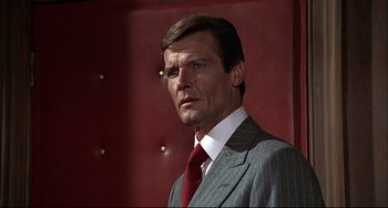Movie still from “The Man with the Golden Gun” (1974), directed by Guy Hamilton – A person wearing a suit and tie; Close Up shot, Low angle