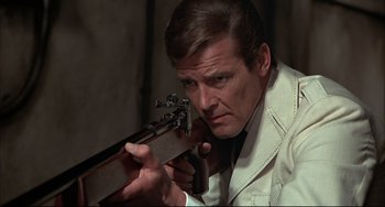Movie still from “The Man with the Golden Gun” (1974), directed by Guy Hamilton – Roger moore as james bond holding a rifle in a scene from the movie live and let die , 1 9 7 3; Close Up shot, Low angle