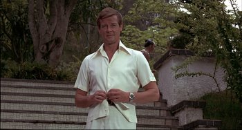Movie still from “The Man with the Golden Gun” (1974), directed by Guy Hamilton – A person wearing a shirt and tie; Medium shot, Low angle