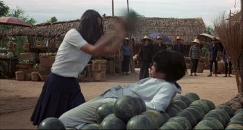 Movie still from “The Man with the Golden Gun” (1974), directed by Guy Hamilton – Two people are fighting over watermelons in a field; Wide shot, Over the shoulder angle