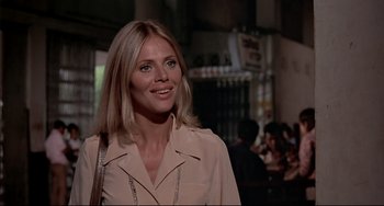 Movie still from “The Man with the Golden Gun” (1974), directed by Guy Hamilton – A woman with blonde hair is smiling for the camera; Close Up shot, Low angle
