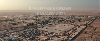 Movie still from “Retrograde” (2022), directed by Matthew Heineman – An aerial view of an airfield with planes parked on the ground; Extreme Wide shot, High angle