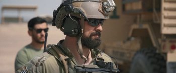 Movie still from “Retrograde” (2022), directed by Matthew Heineman – A person wearing a helmet; Close Up shot, Over the shoulder angle