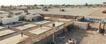 Movie still from “Retrograde” (2022), directed by Matthew Heineman – A group of people standing on top of a concrete slab; Extreme Wide shot, High angle