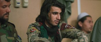 Movie still from “Retrograde” (2022), directed by Matthew Heineman – A person with long black hair; Close Up shot, Over the shoulder angle