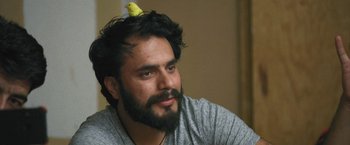 Movie still from “Retrograde” (2022), directed by Matthew Heineman – A man with a bird on top of his head; Close Up shot, Low angle