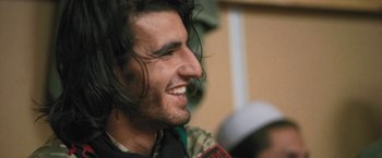 Movie still from “Retrograde” (2022), directed by Matthew Heineman – A person with long black hair; Close Up shot, Low angle