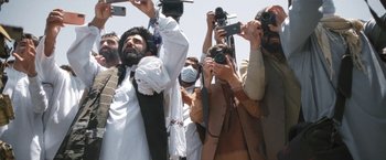 Movie still from “Retrograde” (2022), directed by Matthew Heineman – A group of people taking pictures with their cameras; Wide shot, Low angle