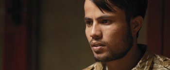 Movie still from “Retrograde” (2022), directed by Matthew Heineman – A person with a beard; Close Up shot, Over the shoulder angle