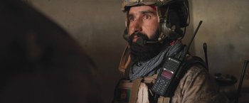 Movie still from “Retrograde” (2022), directed by Matthew Heineman – A man with a beard wearing a military outfit; Close Up shot, Over the shoulder angle