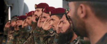 Movie still from “Retrograde” (2022), directed by Matthew Heineman – A group of soldiers saluting in a military formation; Close Up shot, Low angle