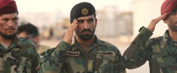 Movie still from “Retrograde” (2022), directed by Matthew Heineman – A man saluting while wearing a military uniform; Close Up shot, Low angle