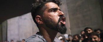 Movie still from “Retrograde” (2022), directed by Matthew Heineman – A person with a beard; Extreme Close Up shot, Low angle