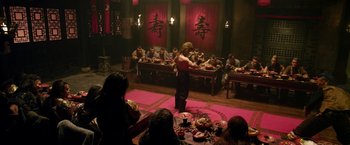 Movie still from “The Man with the Iron Fists” (2012), directed by RZA – A group of people sitting around a table eating food; Wide shot, High angle