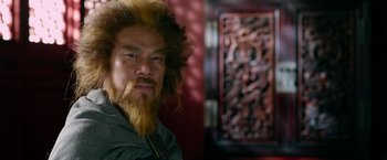 Movie still from “The Man with the Iron Fists” (2012), directed by RZA – A man with long hair and a long beard; Close Up shot, Over the shoulder angle