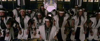 Movie still from “The Man with the Iron Fists” (2012), directed by RZA – A group of men in white robes and white hats; Medium shot, Low angle