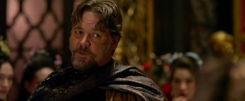 Movie still from “The Man with the Iron Fists” (2012), directed by RZA – A person with a beard wearing a cape; Close Up shot, Over the shoulder angle