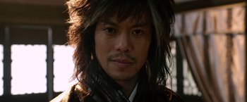 Movie still from “The Man with the Iron Fists” (2012), directed by RZA – A person wearing a jacket; Close Up shot, Low angle