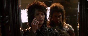 Movie still from “The Man with the Iron Fists” (2012), directed by RZA – A man with long black hair wearing a leather jacket; Close Up shot, Over the shoulder angle