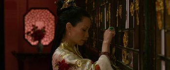 Movie still from “The Man with the Iron Fists” (2012), directed by RZA – A woman in a kimono looking at a green stone; Close Up shot, Over the shoulder angle