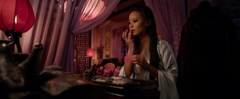 Movie still from “The Man with the Iron Fists” (2012), directed by RZA – A beautiful young lady sitting at a dining table; Medium shot, Over the shoulder angle