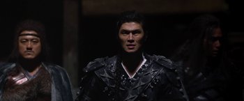 Movie still from “The Man with the Iron Fists” (2012), directed by RZA – A man in a black shirt and a black jacket; Close Up shot, Over the shoulder angle