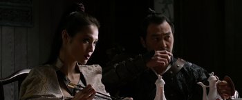 Movie still from “The Man with the Iron Fists” (2012), directed by RZA – A man and a woman are painting something on a table; Close Up shot, Over the shoulder angle