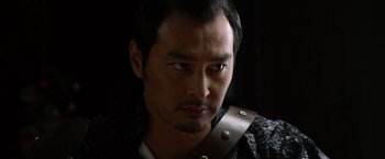 Movie still from “The Man with the Iron Fists” (2012), directed by RZA – A person wearing a black shirt; Close Up shot, Over the shoulder angle