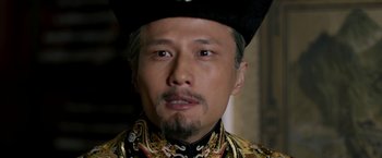 Movie still from “The Man with the Iron Fists” (2012), directed by RZA – A person wearing a hat; Close Up shot, Over the shoulder angle