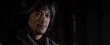 Movie still from “The Man with the Iron Fists” (2012), directed by RZA – A person with long black hair; Close Up shot, Over the shoulder angle