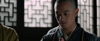 Movie still from “The Man with the Iron Fists” (2012), directed by RZA – A man in a black robe is holding a rosary; Close Up shot, Low angle