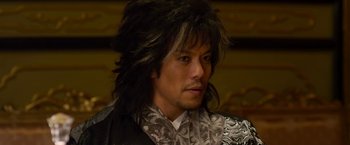 Movie still from “The Man with the Iron Fists” (2012), directed by RZA – A person with long black hair; Close Up shot, Low angle