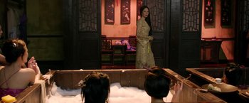 Movie still from “The Man with the Iron Fists” (2012), directed by RZA – A woman standing in front of a group of people; Wide shot, Over the shoulder angle