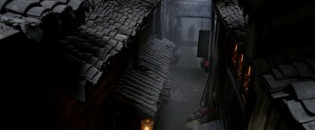 Movie still from “The Man with the Iron Fists” (2012), directed by RZA – A person walking down a street in the dark; Extreme Wide shot, High angle
