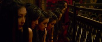 Movie still from “The Man with the Iron Fists” (2012), directed by RZA – A group of people sitting in a row; Close Up shot, High angle