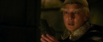 Movie still from “The Man with the Iron Fists” (2012), directed by RZA – A man in a costume holding a cell phone in his hand; Close Up shot, Low angle