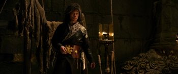 Movie still from “The Man with the Iron Fists” (2012), directed by RZA – A man in a black leather jacket holding a gold belt; Medium shot, Over the shoulder angle