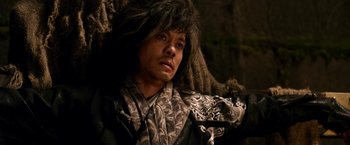 Movie still from “The Man with the Iron Fists” (2012), directed by RZA – A man with long black hair wearing a leather jacket; Close Up shot, Low angle