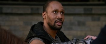 Movie still from “The Man with the Iron Fists” (2012), directed by RZA – A person holding a gun; Close Up shot, Over the shoulder angle