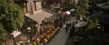 Movie still from “The Man with the Iron Fists” (2012), directed by RZA – A group of men in yellow jackets marching down a street; Extreme Wide shot, High angle
