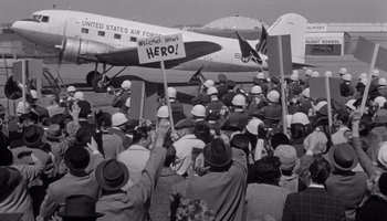 Movie still from “The Manchurian Candidate” (1962), directed by John Frankenheimer – A crowd of people standing in front of an air force plane; Wide shot, Low angle