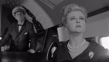 Movie still from “The Manchurian Candidate” (1962), directed by John Frankenheimer – An old photo of a man and a woman in a car; Medium shot, Low angle