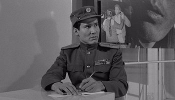 Movie still from “The Manchurian Candidate” (1962), directed by John Frankenheimer – A man in a military uniform writing on a piece of paper; Medium shot, Over the shoulder angle