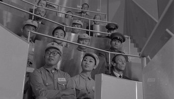 Movie still from “The Manchurian Candidate” (1962), directed by John Frankenheimer – A black and white photo of a group of people in uniform; Medium shot, High angle