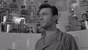 Movie still from “The Manchurian Candidate” (1962), directed by John Frankenheimer – Black and white photograph of a man in front of a group of people; Close Up shot, Low angle