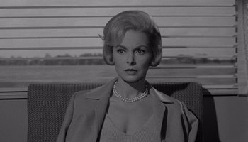 Movie still from “The Manchurian Candidate” (1962), directed by John Frankenheimer – A black and white photo of a woman in a jacket; Close Up shot, Over the shoulder angle