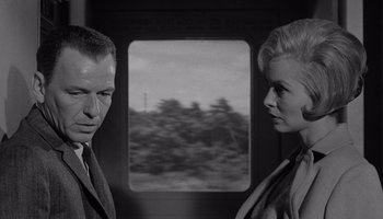 Movie still from “The Manchurian Candidate” (1962), directed by John Frankenheimer – A black and white photo of a man and a woman looking at each other; Close Up shot, Low angle