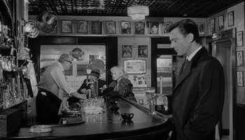 Movie still from “The Manchurian Candidate” (1962), directed by John Frankenheimer – An old photo of people at a bar; Medium shot, Over the shoulder angle