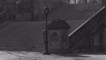 Movie still from “The Manchurian Candidate” (1962), directed by John Frankenheimer – A person standing next to a lamp post on a sidewalk; Extreme Wide shot, High angle